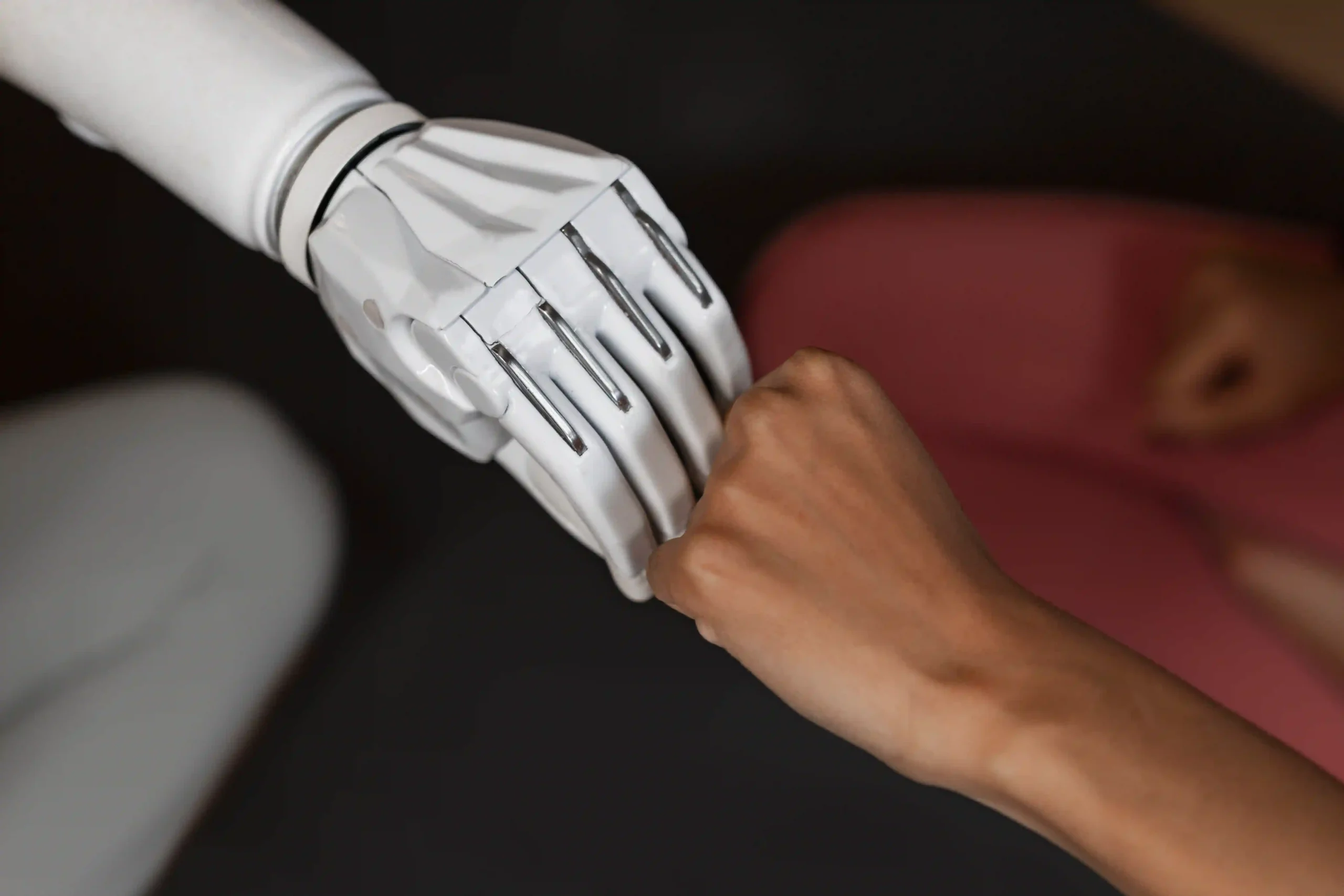 A human hand and a robot hand forming a fist bump, a visual metaphor for the synergy and collaboration between humanity and AI.