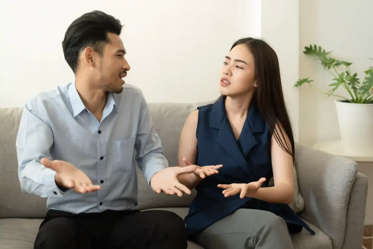 A man and a woman having a conversation on a sofa, with both expressing emotions through gestures, illustrating the idea of recognizing emotions rather than just focusing on stances in communication.