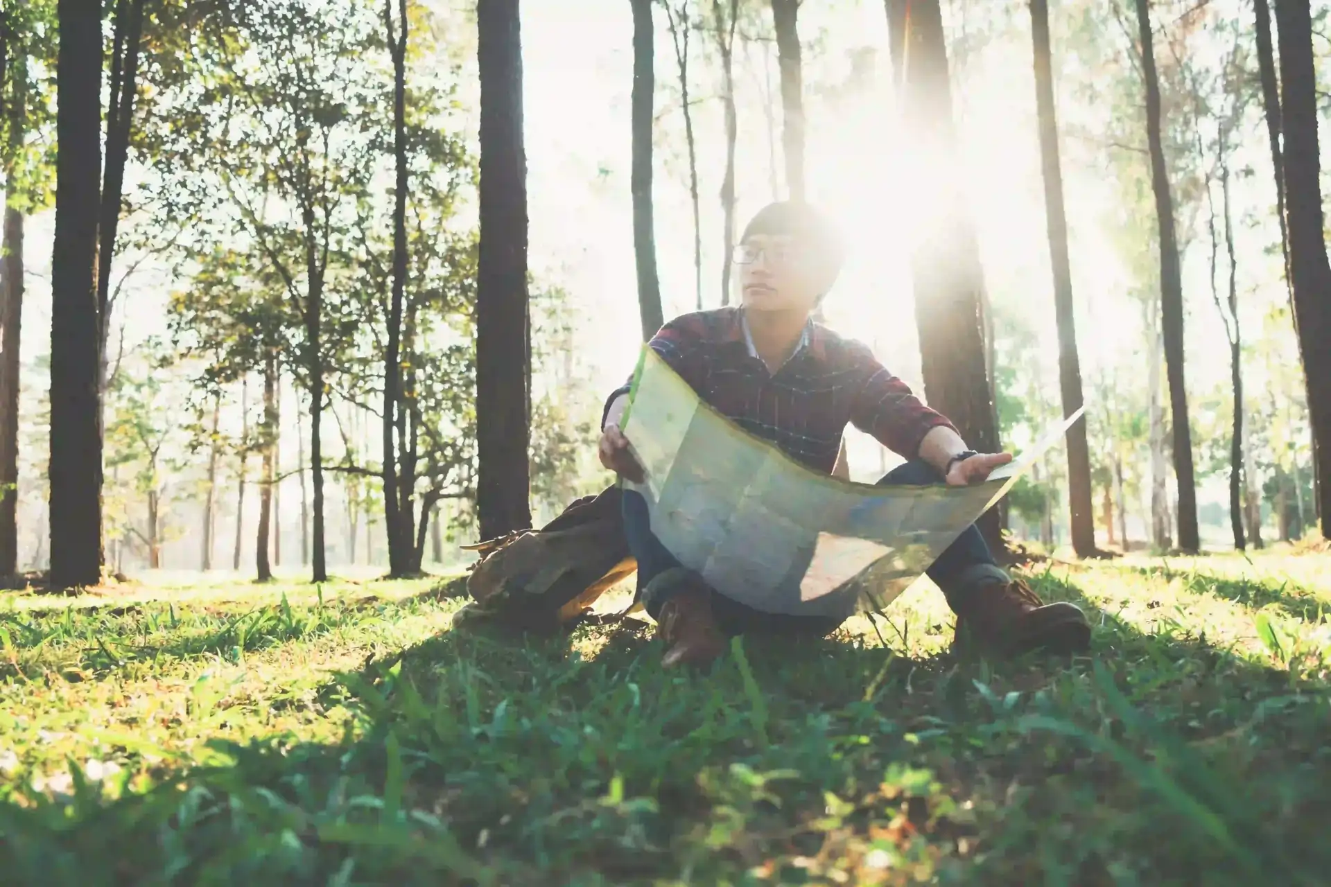 A person stands in a wilderness (representing complex reality), holding a simple diagram of a straight road (representing the theory of growth mindset), scratching his head in confusion.